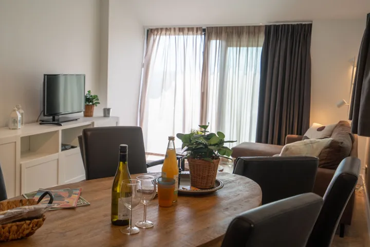 Ronde eettafel met stoelen, met daarachter de zithoek