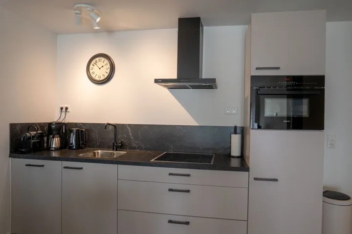 Keuken met inductiekookplaat, combimagnetron en koffiezetapparaten