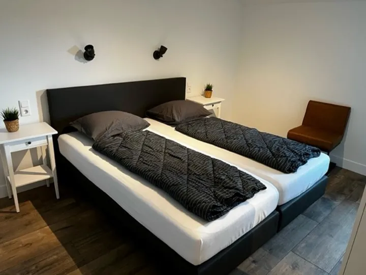 Slaapkamer met tweepersoonsbed en nachtkastjes